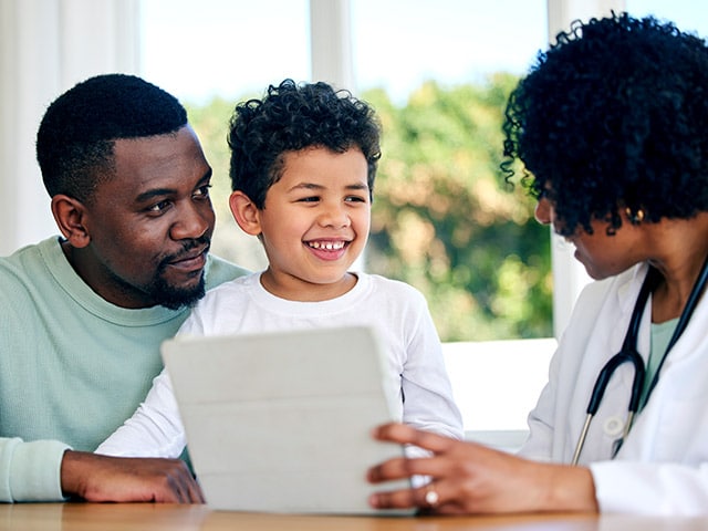 Dad and Son Talking to Doctor About Vaccines Dad and Son Talking to Doctor About Vaccines